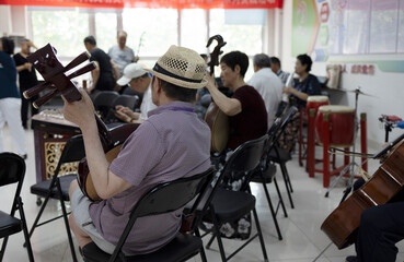 Senior chinese musician playing the cello in concert hall, asian people