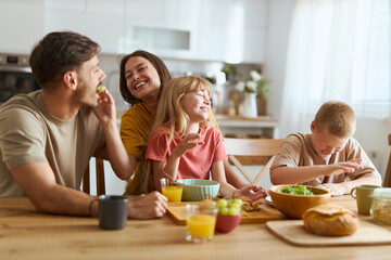 Happy family talking during breakfast at dining table. 