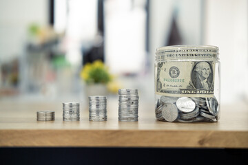 Progressive stacks of coins symbolizing savings growth beside a jar filled with money, emphasizing financial goals and stability. Ideal concept for investment, saving, and wealth-building themes.