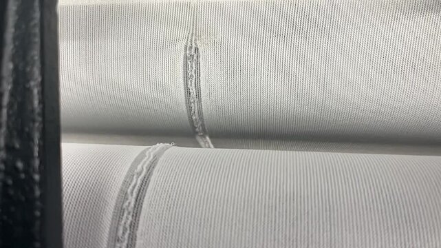 A view of knitting defects on fabric due to thread breakage in a knitting machine in the textile industry.
