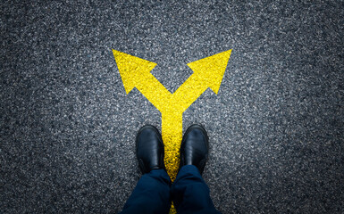 Man standing on asphalt road with arrow signs