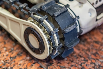 Close-up view of a gray and white robotic device on an uneven, speckled surface, designed for...