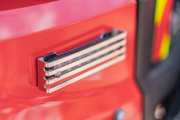 Close-up of a functional fire engine door with a firefighters tool emblem three silver wrenches...