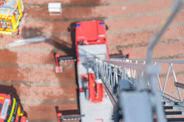 Aerial view of an emergency scene with a red fire truck lifting its ladder and another...