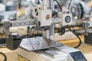 Industrial setting featuring a flexible robotic arm, positioned over a table with scattered...