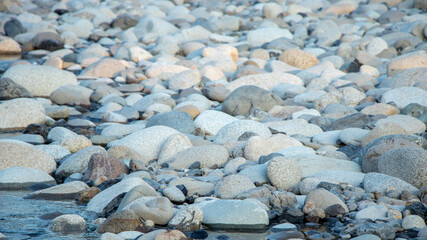 River pebbles with different textures close-up. Stone background.Pebbles or river stone background with vintage filter.