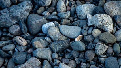 River pebbles with different textures close-up. Stone background.Pebbles or river stone background with vintage filter.