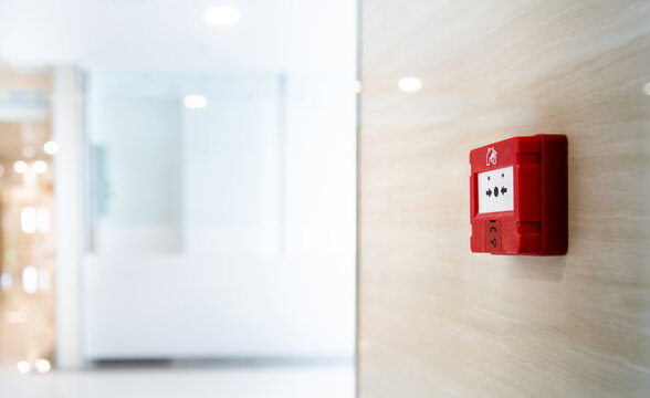 Red fire alarm button on the wall