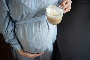 Glowing expecting mother enjoying coffee break at home. Educated perspective on caffeine limits for...