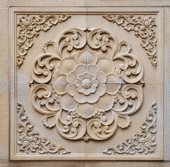 beige stone bas-relief embedded in a wall, a stylized lotus flower, surrounded by ornate, swirling arabesque patterns in a symmetrical design