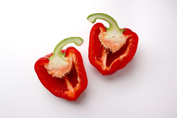 Fresh red bell pepper cut in half on white background