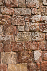 Old medieval weathered sandstone textured wall background backdrop with lichen growing on the surface.