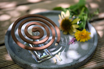 Burning mosquito coil with citronella on a wooden table outdoors in summer. 45 degree angle....
