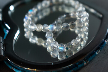 A delicate labradorite bead bracelet, shimmering with its unique play of light, gracefully...