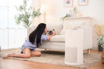 Obraz premium Young Woman Interacts With Her Playful Pug in a Cozy Living Room During Daytime