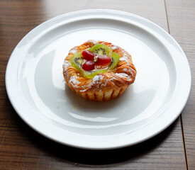 A Danish pastry topped with sliced kiwi and grapes from the Sunday market.