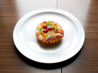 A Danish pastry topped with sliced kiwi and grapes from the Sunday market.