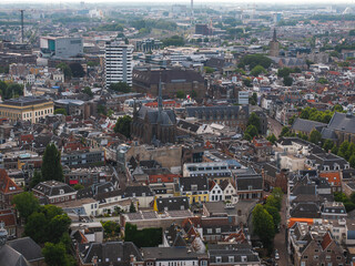 Aerial view of Utrecht, Netherlands, featuring a church spire, red tiled roofs, green spaces, and...