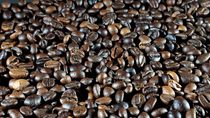 close up of many coffee beans on black background