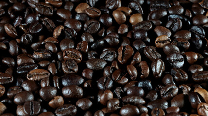 close up of many coffee beans on black background