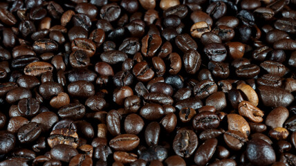 close up of many coffee beans on black background