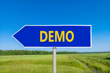 Demo symbol. Concept word Demo on beautiful blue road sign. Beautiful blue sky green grass and forest peaceful nature background. Business and demo concept. Copy space.