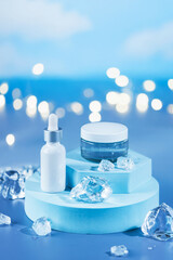 Skincare serum essence glass bottle on ice blue background. Concept summertime beauty product....