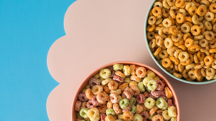  Round cereals and colourful rings bowls on pastel background for breakfast on pastel background