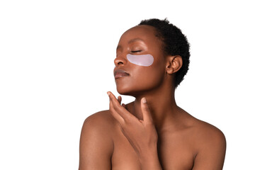 Woman applying under-eye patches for skin care routine with relaxed expression while enhancing...