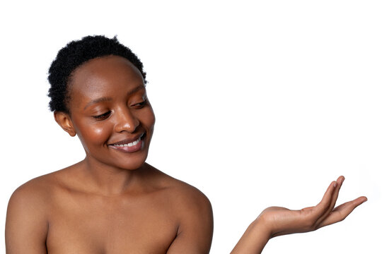 Smiling woman with short hair gestures towards an invisible object in a minimalist setting against a white background - Powered by Adobe