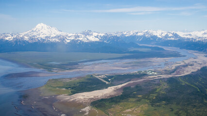 Aerial view of a river and snow covered mountains in Alaska © Linda