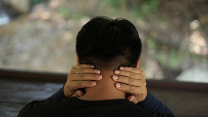 A young asian man athlete with lower backache, neck pain and shoulder pain, injury or strained...