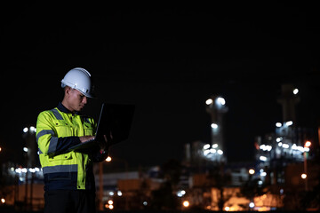 Industrial engineer night inspection at refinery or petrochemical plant walkie-talkie hand and...