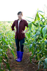 Young man farmer standing in corn field
