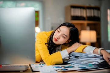 Tired businesswoman resting on a pile of paperwork, overwhelmed by workload and pressure in office