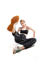 A young model poses with one leg lifted and a confident expression, highlighting her sporty outfit...