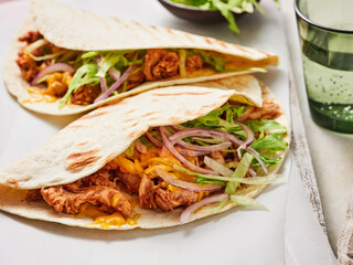 Delicious pulled pork burrito is filled with tender meat, fresh coleslaw, lettuce, and cheese, all wrapped in a warm tortilla, enjoyed in a relaxed dining atmosphere
