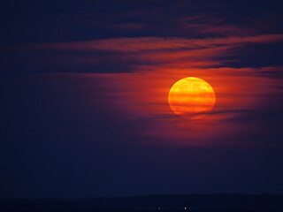 Strawberry Moon rises with a light veil, red and large, over the Greifswalder Bodden on the evening...