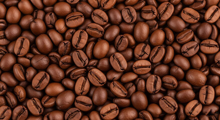 Naklejka premium Numerous roasted coffee beans, filling the entire frame. The beans vary slightly in shade, ranging from medium to dark brown, and show visible textures and subtle glints of light, suggesting a smooth.