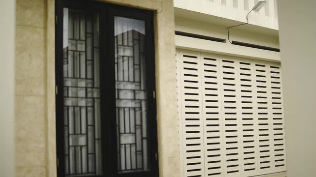 Modern Building Exterior with Decorative Window Grille and Roller Shutter