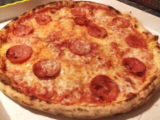Pizza with spicy salami and mozzarella cheese, close up, isolated. Зizza delivery. Italian food. Italian pizza with mozzarella, tomatoes, salami.
