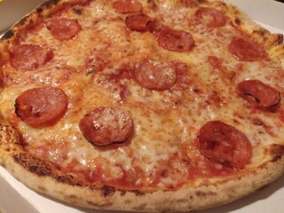 Pizza with spicy salami and mozzarella cheese, close up, isolated. Italian food. Italian pizza with...