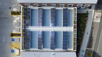 Drone aerial photograph of an array of Solar Panels located on the roof of a commercial building.