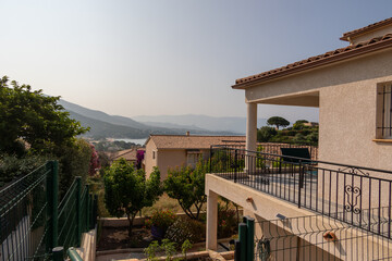 View over garden and rooftops to bay, Corsica
