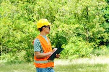 Environmental engineer man in the forest notes the ecological situation. Ecologist technician with...