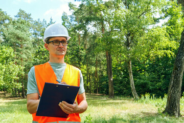 Environmental engineer man in the forest notes the ecological situation. Ecologist technician with...