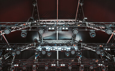 Close-up view of a dense lighting grid structure with an array of mounted LED wash lights, moving...