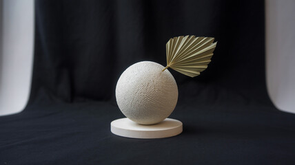 The sphere is made of a ribbed, textured material with concentric spiral grooves creating a wave-like pattern