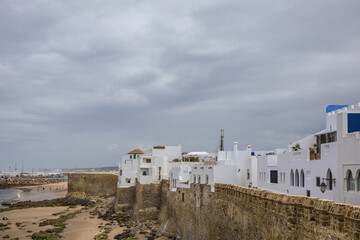 Mury obronne Asilah nad oceanem pod pochmurnym niebem