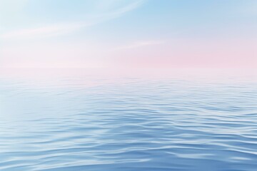 Obraz premium Gentle waves ripple across a calm ocean reflecting the soft pastel colors of a serene sunset sky